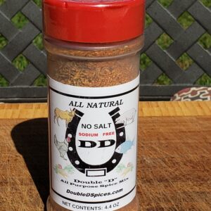 A jar of seasoning sitting on top of a wooden table.