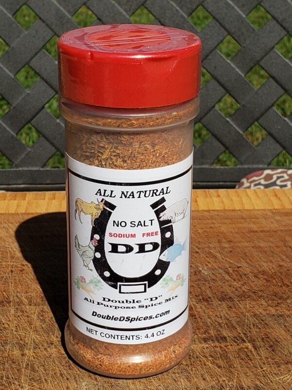 A jar of seasoning sitting on top of a wooden table.