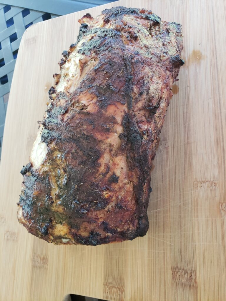 A piece of meat on top of a wooden cutting board.